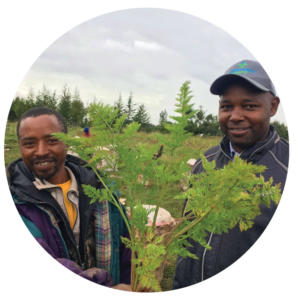 Peter and another local farmer proudly show the carrots from their harvest.