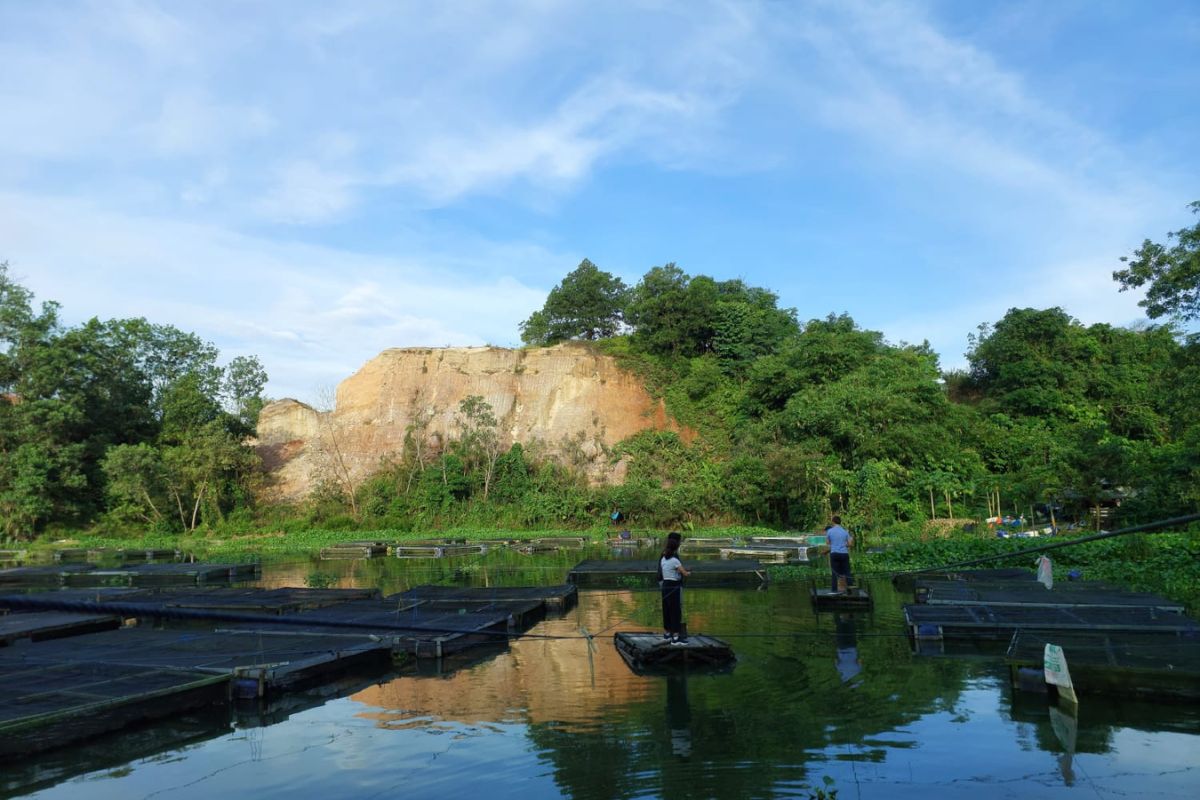 two people fish from rafts on a dark pond