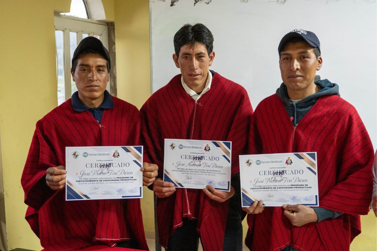 Nelson and his two brothers stand with their training certificates
