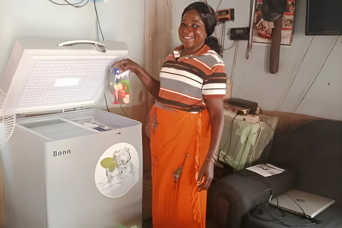 a woman stands in a room opening a chest fridge