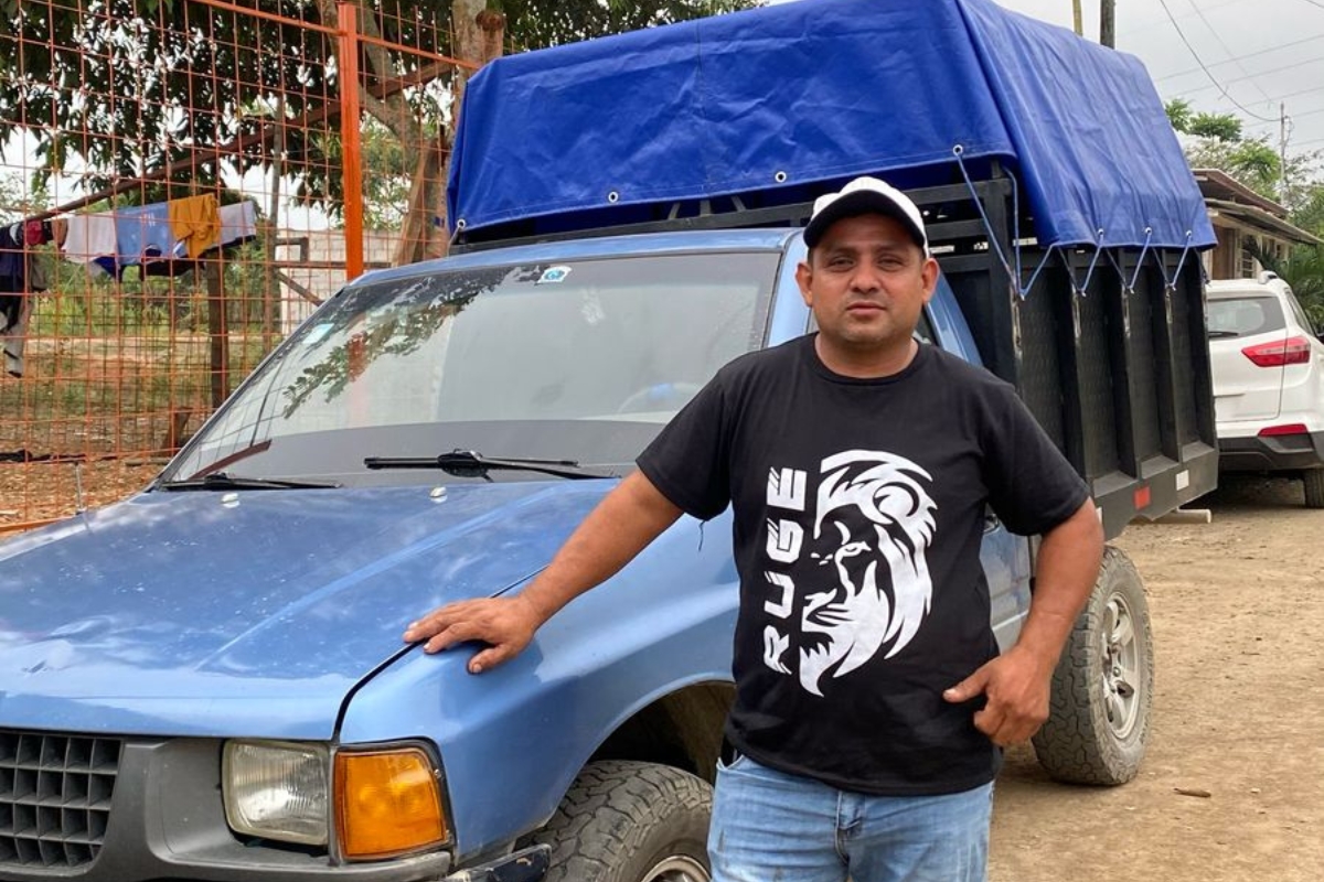 a man stands next to a blue truck
