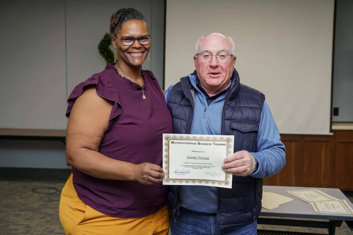 Charity displays her business training certificate with Denny Vander Molen, founder of Jackson Endeavors.