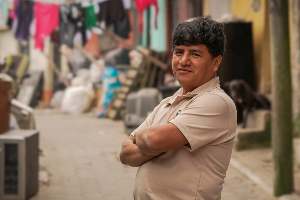 a man stands confidently in a colorful alley with his arms crossed