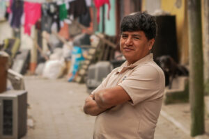 a man stands confidently in a colorful alley with his arms crossed