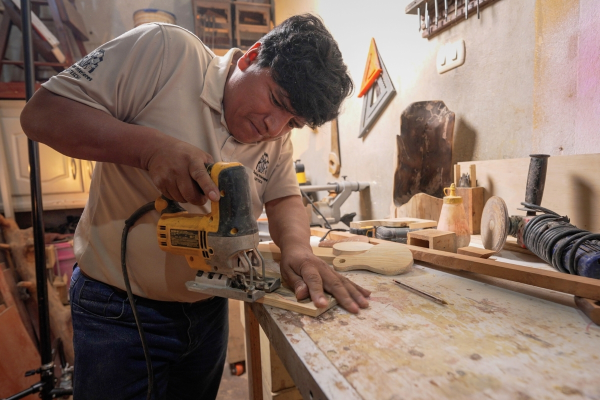 a man using a saw at a carpenter's bench