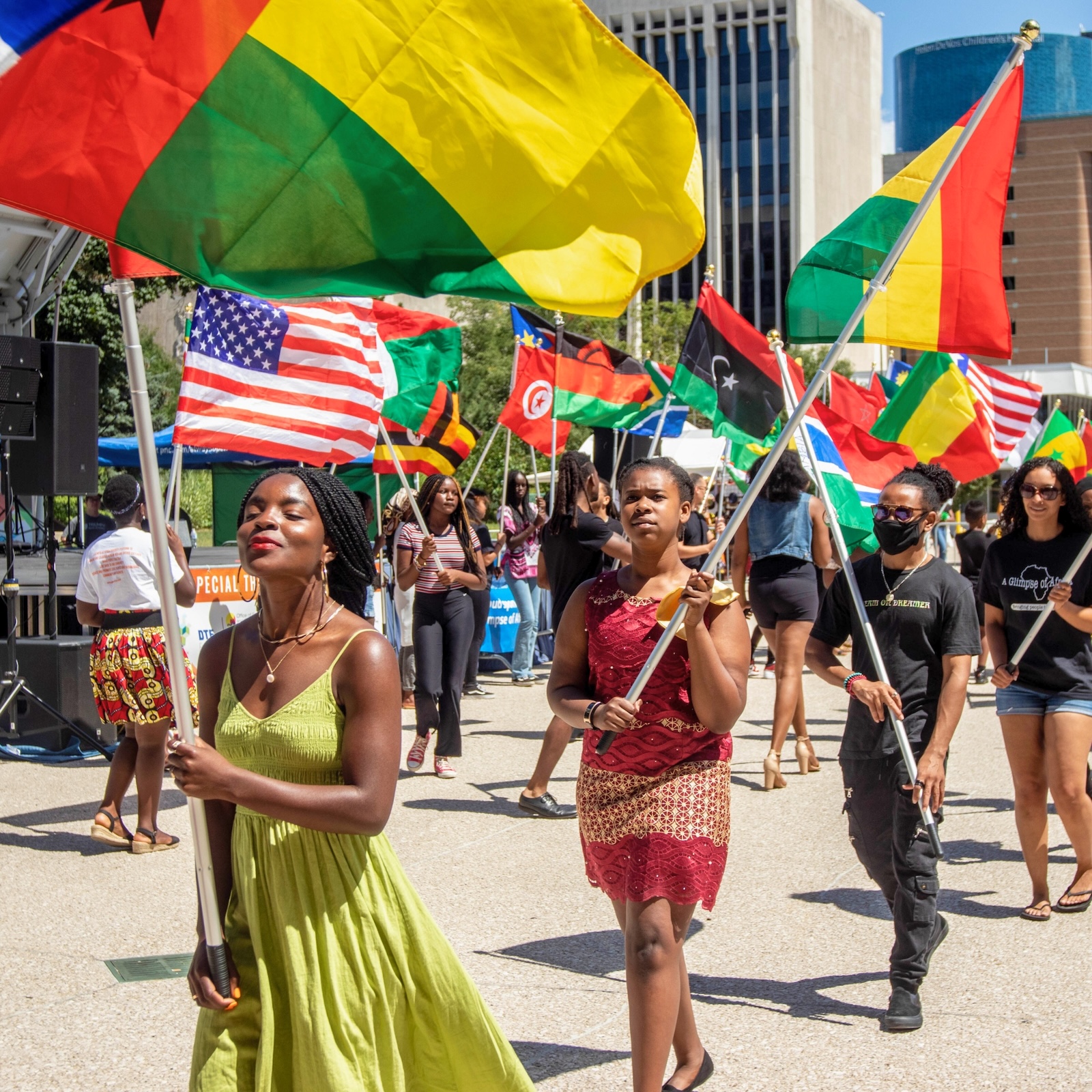 people walk in a line waving flags of different African countries