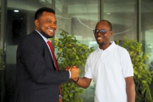 two men shake hands and smile