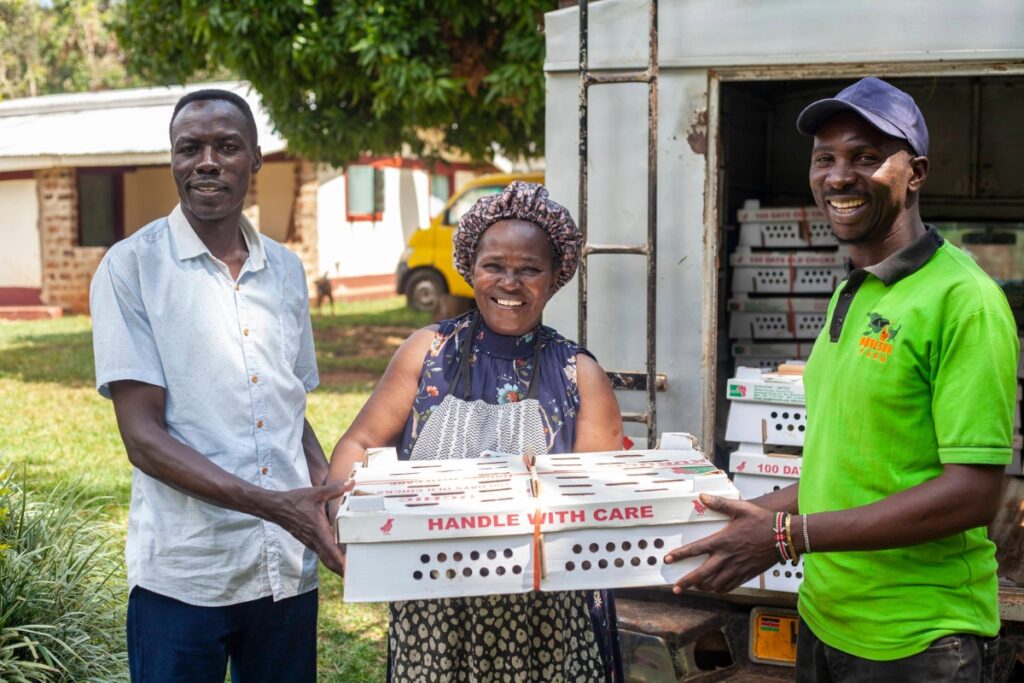 woman and two men holding a box that says handle with care