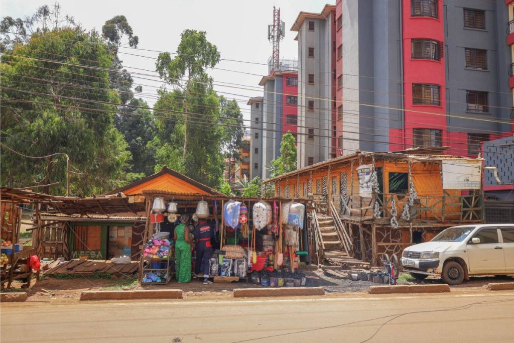 Vendor stand with various goods for sale in front of other buildings