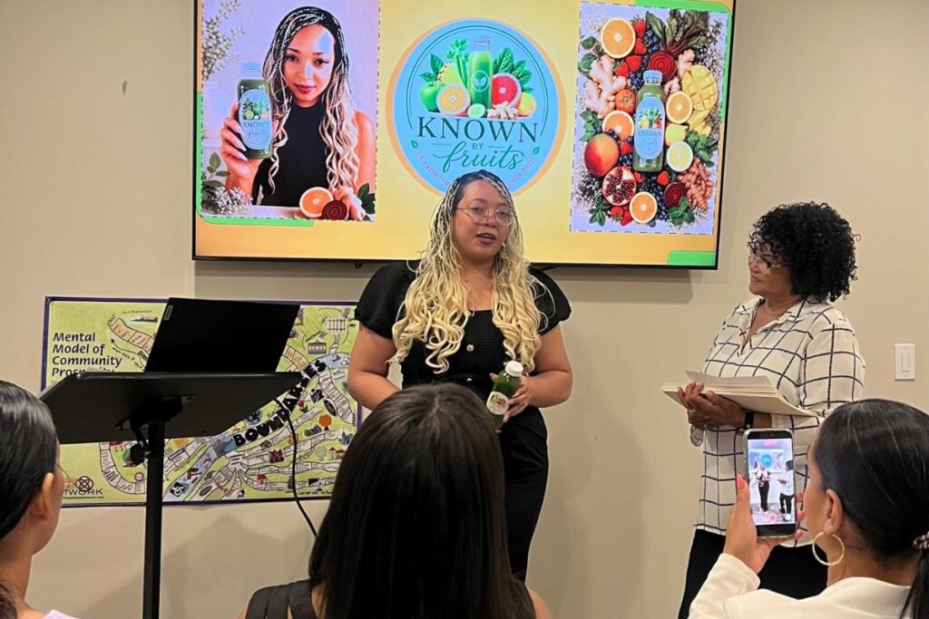 woman giving presentation with three women seated in folding chairs