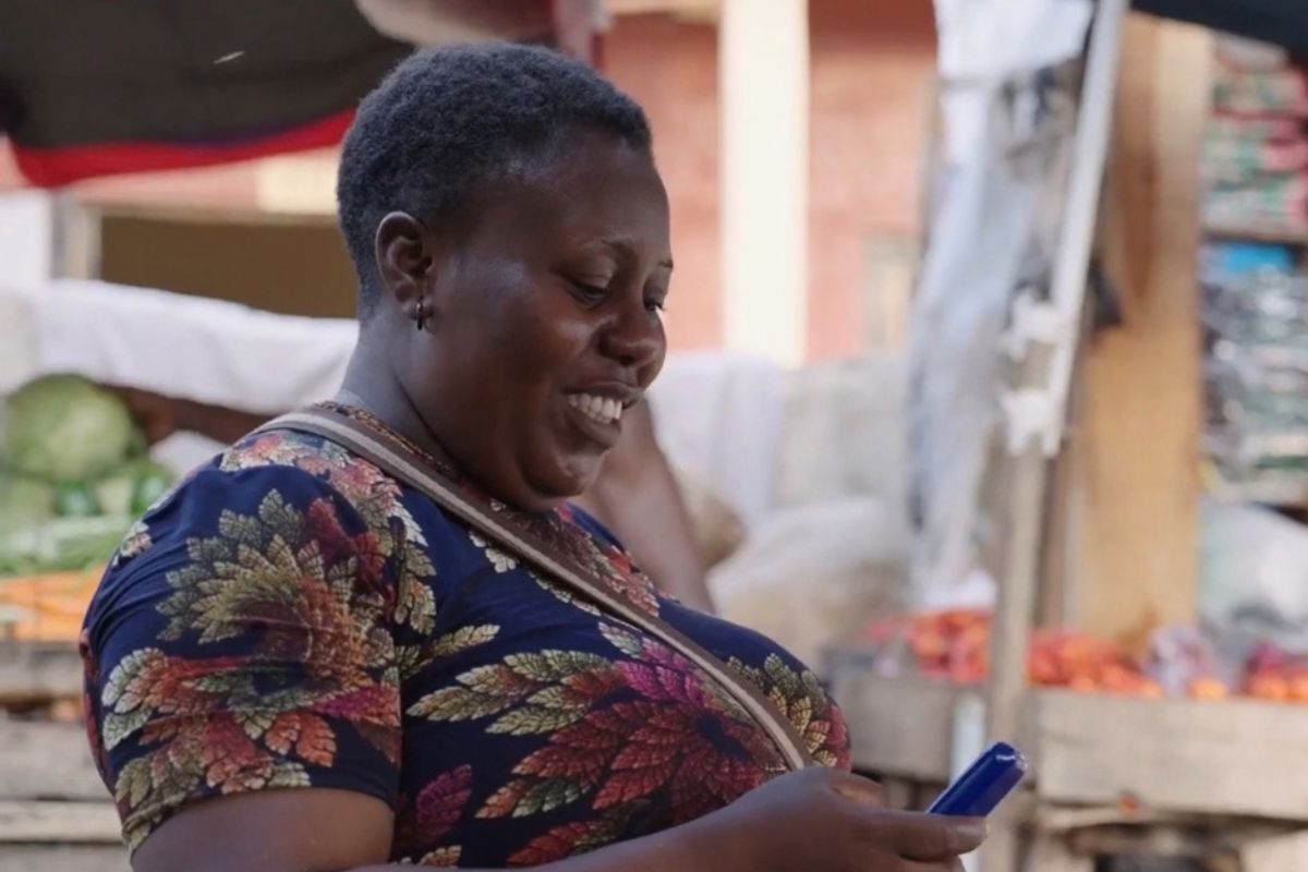 woman smiling and looking at a blue phone